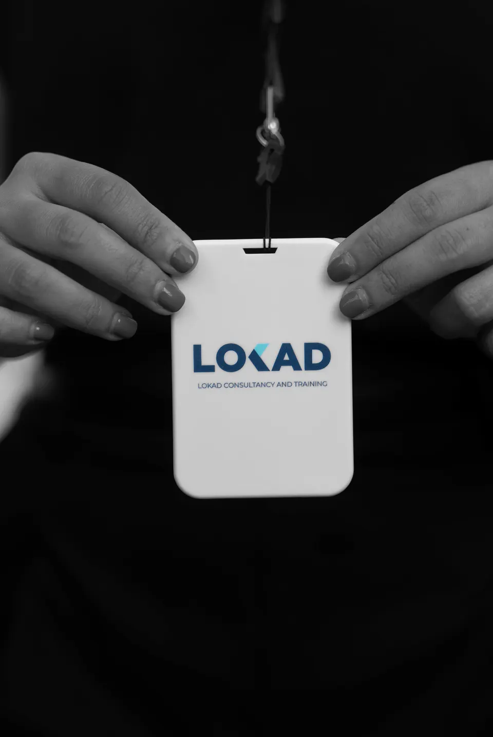 Hands holding a LOKAD badge
