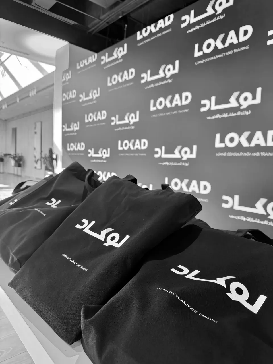 LOKAD tote bags in front of a LOKAD backdrop