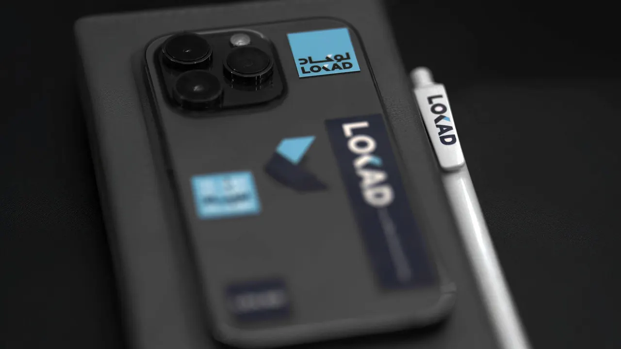 Phone case with LOKAD stickers next to a LOKAD pen